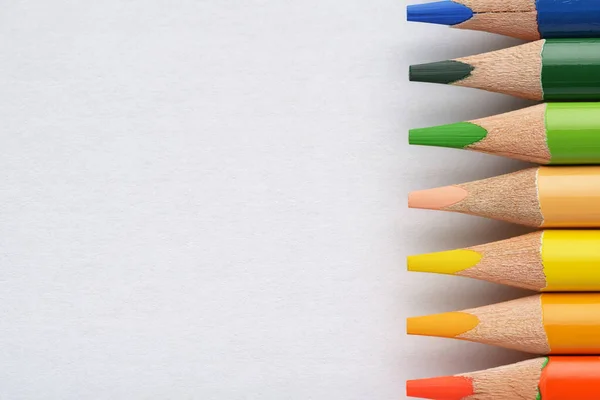 Багатокольорові олівці на білому папері — стокове фото