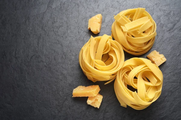 Fettuccine pasta with Parmesan cheese on black background — Stock Photo, Image