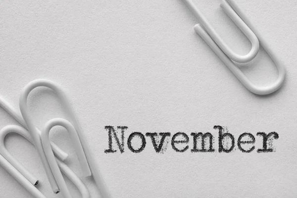 White plastic paper clips with November word — Zdjęcie stockowe