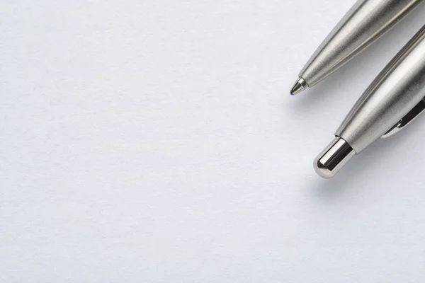 Металлическая шариковая ручка на белом бумажном фоне — стоковое фото