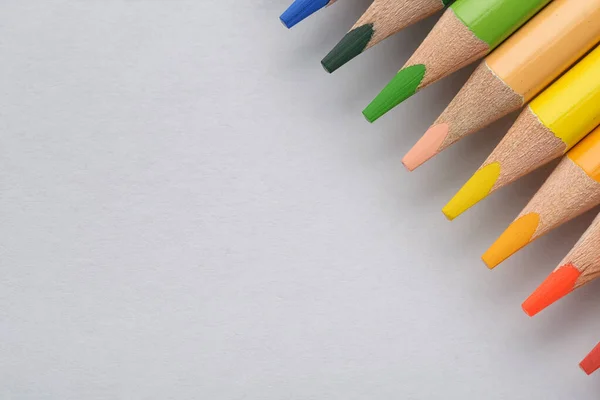 Багатокольорові олівці на білому папері — стокове фото