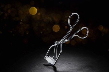 Kopya alanı ile siyah arkaplan üzerinde metal kirpik bigudisi