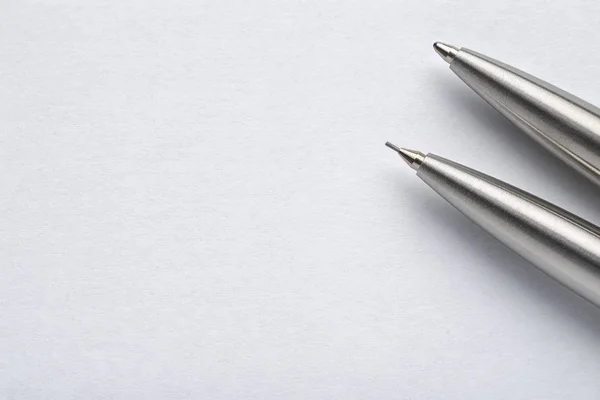 Penna a sfera in metallo e matita automatica su sfondo bianco — Foto Stock
