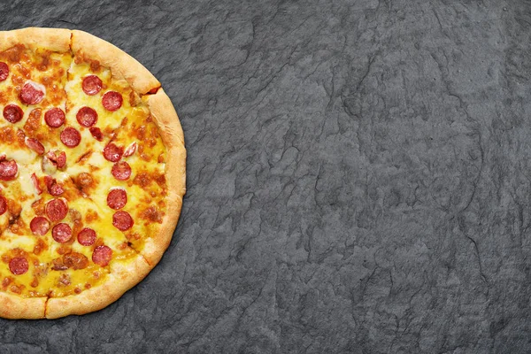 Sosisli biberli pizza, domates sosu ve siyah arkaplanda peynir..