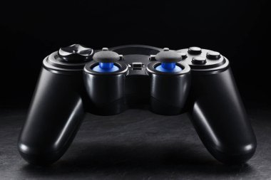 Siyah plastik kablosuz oyun sahası veya siyah tahta arka planda joystick.
