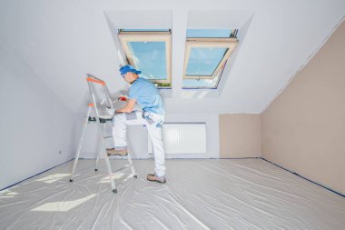 Ev iç repainting. Daire duvar boyama tarafından yenileniyor. Beyaz ev erkeği işçi.