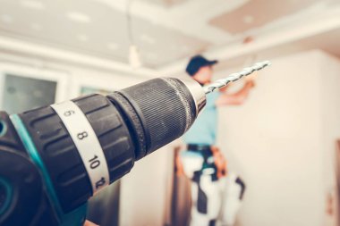 Elektrikli aletler, Akülü matkap sürücü Remodeling daire ve arka planda yüklenici çalışma.