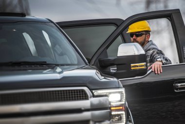 Çalışkan beyaz erkek Sarı kask giyiyor. Endüstriyel tema. İşçi ve kurumsal onun kamyonet.