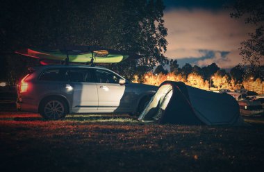 Tatil kamp çadır gece ile. Modern çadır ve kayaklar üzerinde Port Bagaj ile araç.