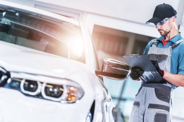Ön araç değerlendirme beyaz araba tamircisi tarafından sahip olduğu. Otomotiv kavramı.