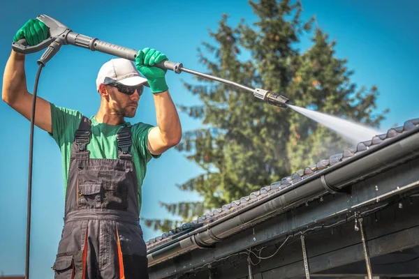 白人男性が透明なプラスチック製のカーポート屋根を洗浄します 圧力洗濯機の仕事 — ストック写真