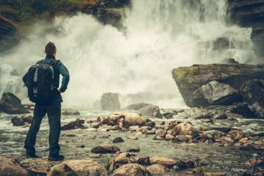 Doğal şelale ve Norveç manzara keşfetmek sırt çantası ile beyaz erkek