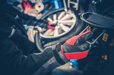 İş yerinde icin. Otomotiv Servis işçisi. Mevsimlik lastik değiştirme.