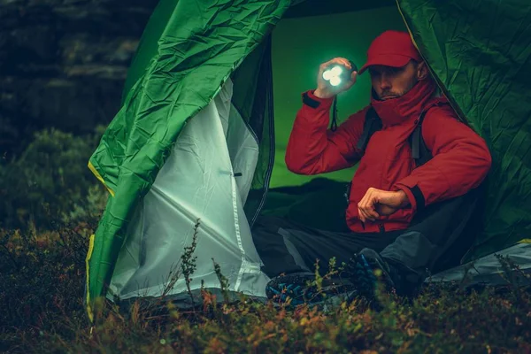 高加索露营者与手电筒在他的帐篷里 在下雨的晚上 而在远足 — 图库照片