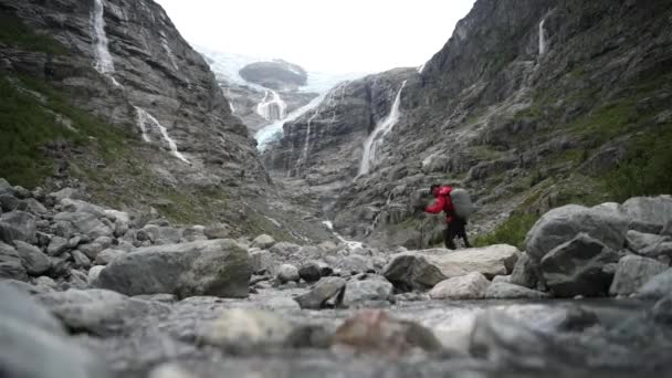 ノルウェーの Kjenndal 氷河の道でのバックパッカー — ストック動画