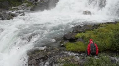 Beyaz uzun yürüyüşe çıkan kimse vahşi doğada doğal şelale keşfetmek. Ağır çekim görüntüleri