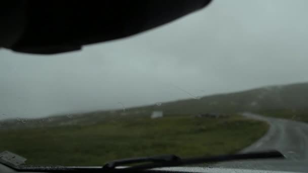 車のフロント ガラス ワイパーのスローモーション映像 荒野スカンジナビア道路と雨の天気予報 — ストック動画