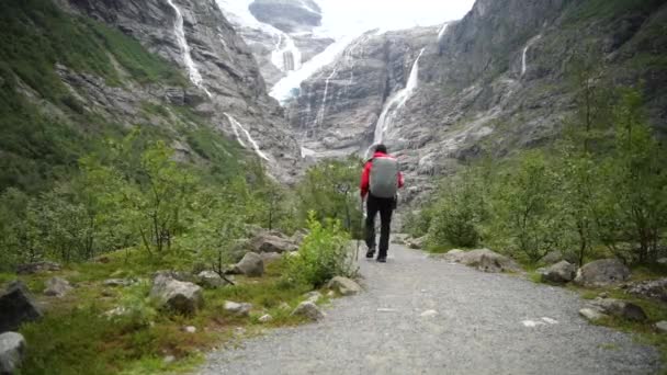 ノルウェーの氷河の道でバックパックを持つ男性 — ストック動画
