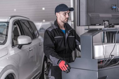 Otomatik servis teknisyeni araç verileri analiz bilgisayar önünde.