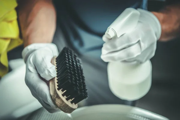 Cleaning Brush and Detergent in Hands of Professional Cleaner