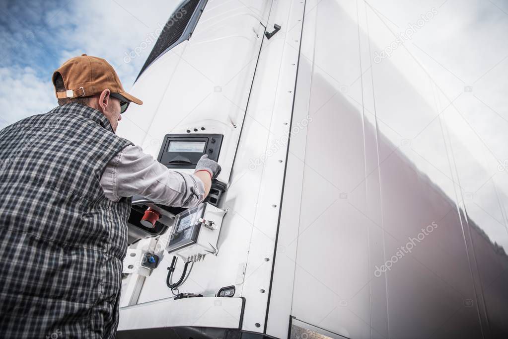 Refrigerated Semitrailer Cargo. Adjusting Temperature by Caucasian Truck Driver.