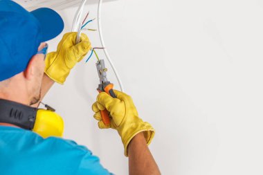 Elektrikçi ve işini. Daire içinde elektrik kabloları hazırlanıyor.