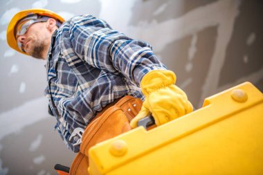 Profesyonel sarı vaka içinde güç araçları ile Yüklenici Remodeling. Onun 30s sarı baret beyaz işçi.