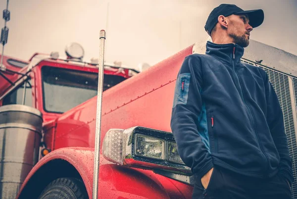 フロントの彼赤い光沢のある半トラックで 代の白人のトラック運転手 光の雨の天気 職業トラック ドライバー — ストック写真