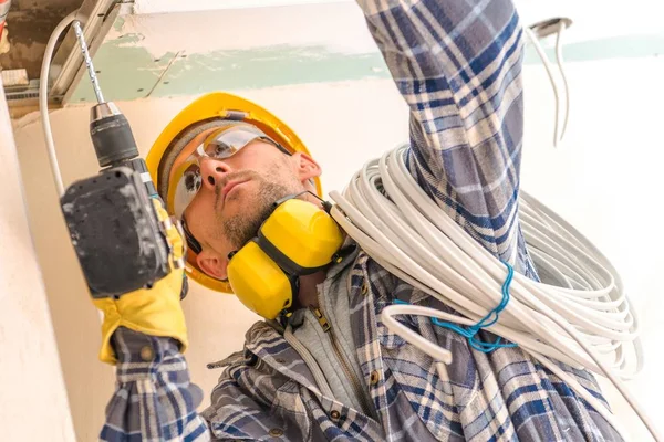 Caucasian Construction Worker with Electric Cable and Drill Driver.
