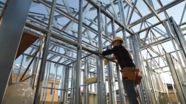 Onun yeni yapılan iskelet çelik çerçeve yapısı zevk beyaz inşaat işçisi