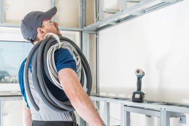 İş için elektrikçi hazır. Onun omzuna kablolar yığını ile onun 30s beyaz elektrik işçisi.