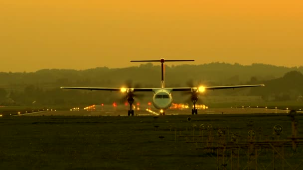 Taxi de avión turbohélice desde la pista al atardecer . — Vídeo de stock