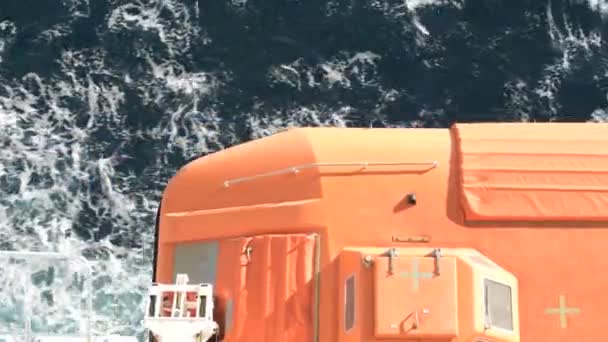オレンジクルーズ船救命艇のクローズアップ映像の下で海水を通過し オレンジクルーズ船にて海水を通過する救命艇の近接映像 — ストック動画