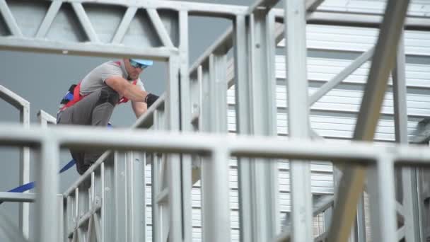 Kaukasischer Bauunternehmer in seinen 30er Jahren auf einem Stahlgerüst. Sicherheitsgurt-Ausrüstung. — Stockvideo