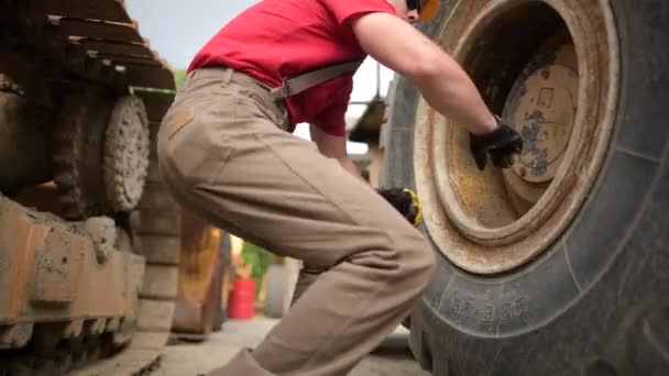 Industrieel thema. Heavy Equipment Mechanic controle op bulldozer wielen — Stockvideo