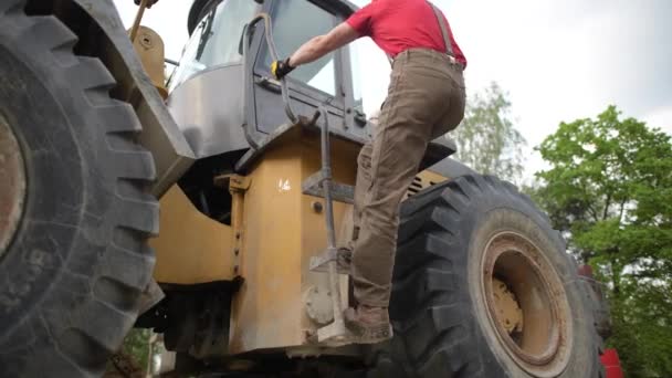 Bulldozer-Fahrer bereitet sich auf seinen Job vor. Bauindustrie. — Stockvideo