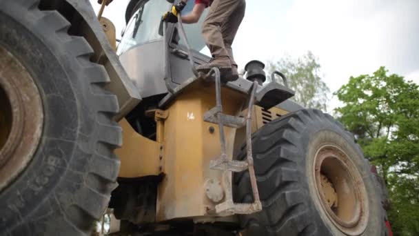 Kaukasiska bulldozer operatör i sin 30s förbereder sig för sitt jobb. Temat byggnadsindustrin. — Stockvideo