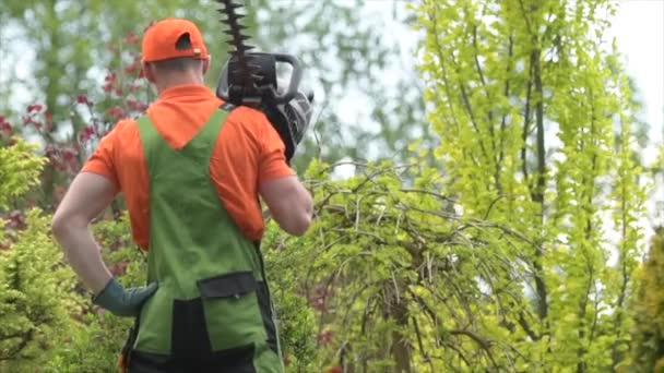 Кавказский садовник 30 лет с помощью бензинового триммера Power Garden Tool . — стоковое видео