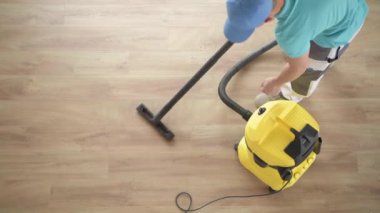 Kafkas erkekler süpürme daire yeni parke zemin. Ev Temizleme süresi.