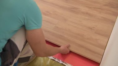 Zemin Panelleri Yükleyici. 30'lu Yaşlarında Kafkas Remodeler İşçisi Yeni Ahşap Döşeme Montajı.
