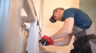 Beyaz sıhhi tesisat Installer onun 30s banyo ekipmanları yükleme.