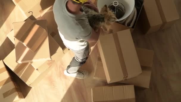 Egyetlen kaukázusi Férfi költözés az új lakás az ő kis kutya. — Stock videók