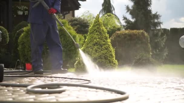 Mannen met behulp van hogedruk reiniger voor het schoonmaken van de oprit. — Stockvideo