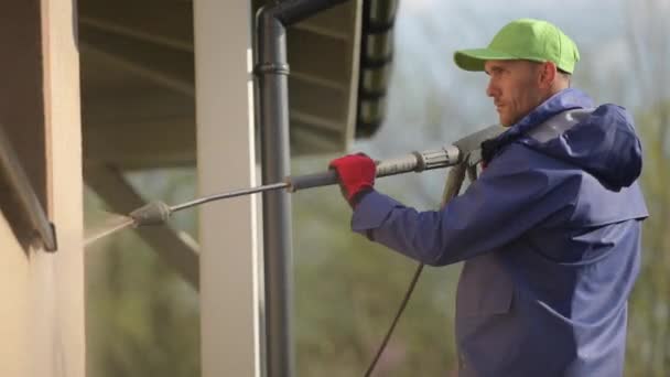 Mannen reinigen zijn huis muren met behulp van hogedrukreiniger. — Stockvideo