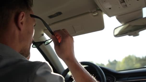 晴れた日に彼の車を運転する前にサングラスを着用した白人男性 スローモーションフッテージ — ストック動画