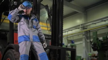 Forklift Operatörü Forlif'in Önünde 30'larında. Kamera Hareketi ile 4k Çekim.