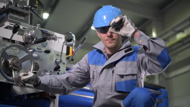 Metal Works Lathe Operator em seus 30 anos. Trabalhador vestindo óculos de proteção e capacete — Vídeo de Stock