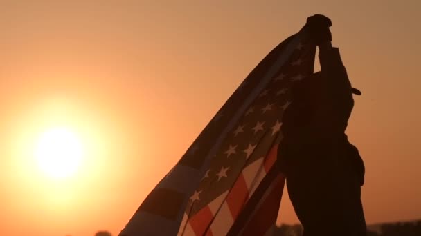 Western mężczyzn noszenie, Obchody Święta Niepodległości macha dużą amerykańską flagę podczas Scenic Zachód słońca widok perspektywiczny. Stany Zjednoczone Ameryki Patriot w kowbojski kapelusz. — Wideo stockowe