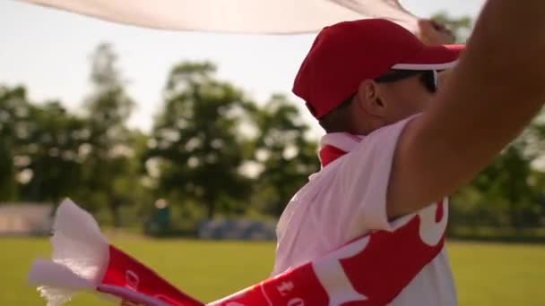 Польський футбольний вболівальник працює з польським національним прапором в повільному русі — стокове відео