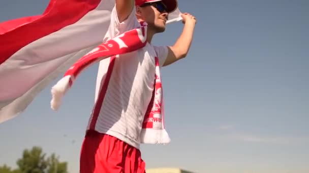 Польський футбольний вболівальник у своєму 30-х роках працює з польським національним прапором в уповільненому Русі — стокове відео